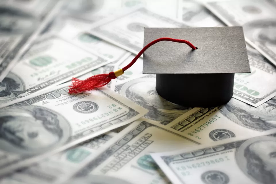 Graduation mortarboard on a pile of money.